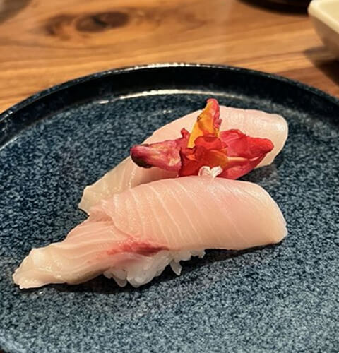A blue plate of vibrant sushi pieces
